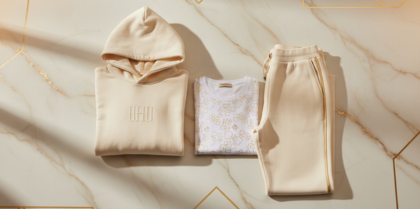 Beige hoodie, sweatshirt, and jogger pants on a marble surface